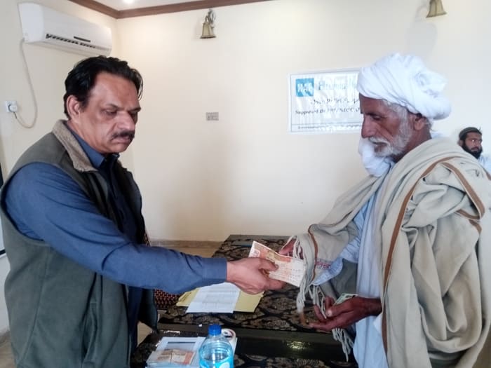 A recipient collecting their household's flood relief payment