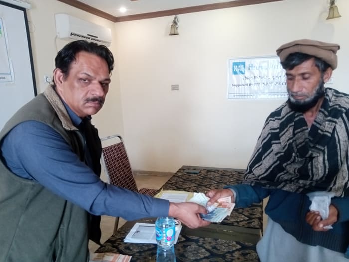 A recipient collecting their household's flood relief payment