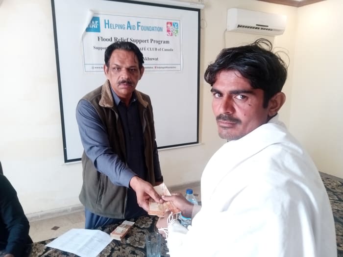A recipient collecting their household's flood relief payment
