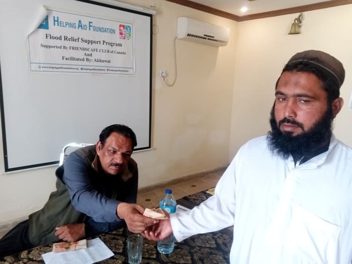 A recipient collecting their household's flood relief payment
