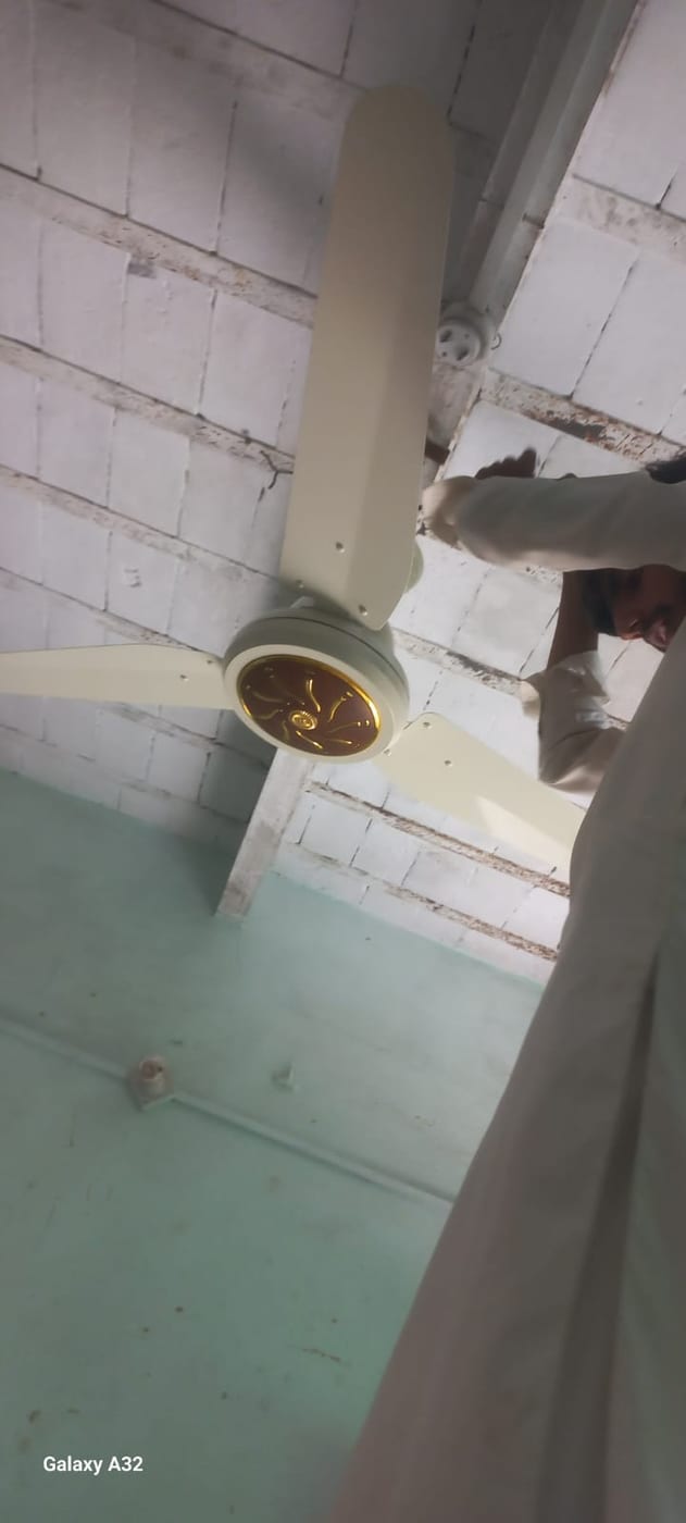 A DC ceiling fan being fitted during a solar installation visit